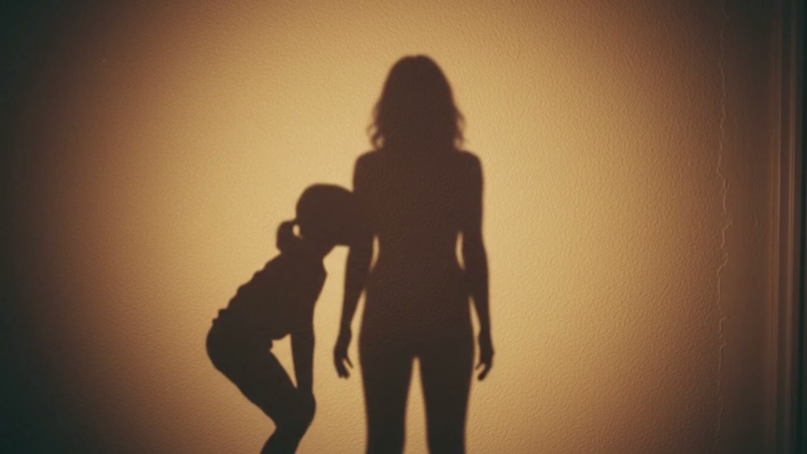 The shadow of a child bowing beside the shadow of a grown woman.